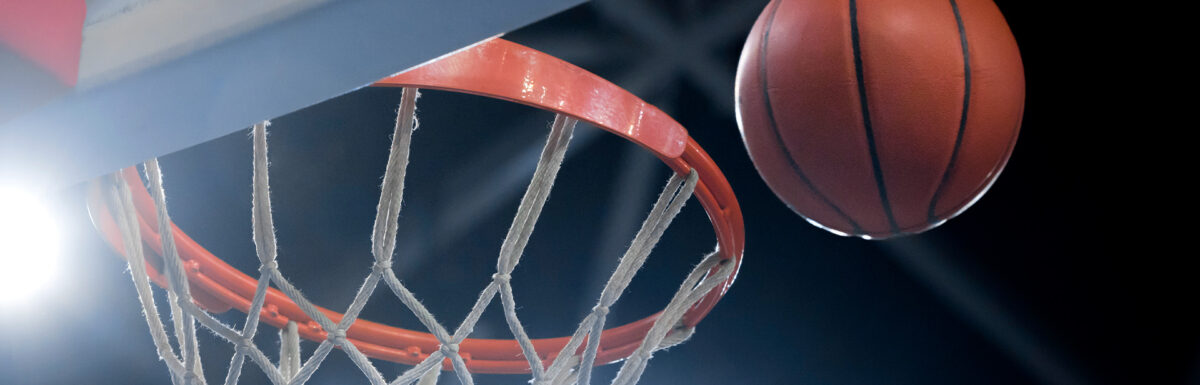 A photo of a basketball heading for a hoop