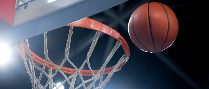 A photo of a basketball heading for a hoop